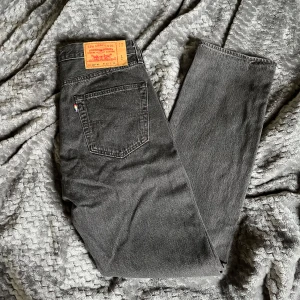 Levi's 501 grå jeans - Säljer ett par klassiska grå Levi's 501 jeans i premiumkvalitet. Byxorna har rak passform, fem fickor och knappgylf. Perfekta för dig som gillar tidlös stil och vill ha ett par jeans som funkar till det mesta. Aldrig använda. Bara att höra av sig för fler bilder eller funderingar
