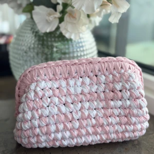 Virkad necessär i rosa och vitt - Superfin handgjord necessär i en mix av babyrosa och vitt. Perfekt att ha smink eller småprylar i. Söt och unik accessoar till din samling! Kika gärna in vår Instagram @design.by.bela för andra necessärer och väskor. Du kan även designa din egen utifrån din favoritfärg. 