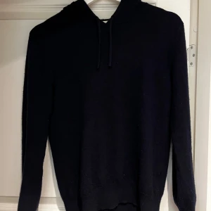 Cashmere hoodie  - Snygg och enkel mörkblå cashmere hoodie med långa ärmar och huva. Perfekt för en avslappnad stil. Har fått syningar i armbågarna men annars fint skick.