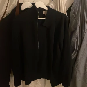 Stickad cardigan  - Säljer en mörkblå cardigan från H&M med dragkedja framtill och ribbade detaljer vid krage och ärmslut. Enkel och stilren design som passar till många tillfällen. Perfekt för dig som gillar en clean look. Passar både S och m!