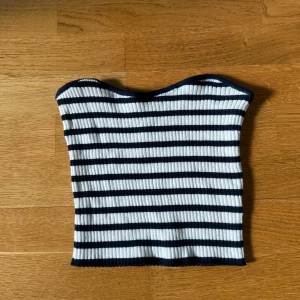 Randig ribbad tubtopp - Säljer en vit och marinblå ribbad tubtopp. Jättesöt och passar perfekt till sommaren.