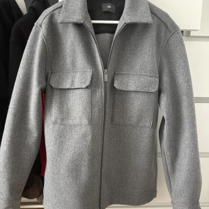 Grå jacka  - En grå tunn vår/sommar jacka, köpt på h&m och har används några få ggr.