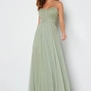 Ljusgrön långklänning med smala axelband - Säljer denna slutsålda ljusgröna långklänning med smala axelband och v-ringad överdel. Klänningen har markerad midja och ett luftigt, svepande kjolparti. Perfekt för bal eller festliga tillfällen!!💕💕 Skriv för fler bilder