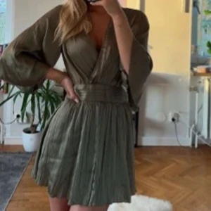 Grön klänning - Säljer denna superfina gröna satinklänning från Zara som knappt är använd, storlek S! Klänningen  par shorts under kjolen❤️