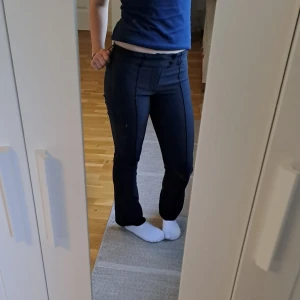 Svarta kostymbyxor från H&M - Säljer ett par svarta kostymbyxor från H&M i storlek 164. Byxorna är utsvängda och lågmidjadepassform, sitter perfekt i midja. Perfekta till många olika outfits och enkla att matcha.