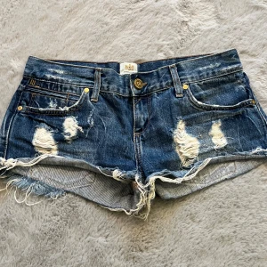Lågmidjade jeans shorts - As snygga jeans shorts med låg midja och slitningar. Midjemått tvärs över: 41 cm💞💞💞