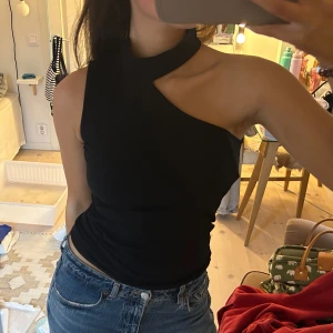 Svart oneshoulder topp - Säljer denna fest topp som är assymetrisk. Svart i storlek S. Från NAKD. Knappt använd och därför inga defekter. Snyggt till ett par lågmidjade jeans eller kostymbyxor🔥Köparen står för frakten! Kvar så länge det ej står SÅLD