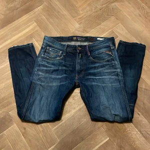 Replay FC Barcelona Anbass jeans - Mörkblå jeans från Replay i modellen Anbass, med FC Barcelona-detaljer. Klassisk femficksdesign, röda sömmar och snygg tvätt. W30/L32. Säljer då de inte får plats i garderoben. Jeansen är lite slitna, men kan vara snyggt att designa med!