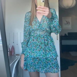 Blommig volangklänning ZARA - Säljer den här super fina klänningen från Zara som är helt oanvänd med prislappen kvar. Finns inte längre i butik, nypris 500