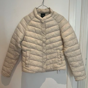 Beige pufferjacka från Everest - Super fin vår jacka från Everest🌸 i krämvit, jackan har knappar både i fickorna och fram. Hittar inte någon storlek men skulle säga att det är en Xs🌷 (missfärgning/fläck på insidan av jackan, se bild 5, inget som syns när man har på sig jackan)