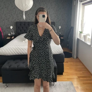 Mönstrad omlottklänning - Svart och vit mönstrad omlottklänning. Vero Moda strl S. Knytning i midjan. Använd fåtalet gånger.