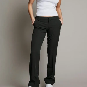 Svarta kostymbyxor från Bikbok - Snygga svarta kostymbyxor från Bikbok med en klassisk design. Modellen Vera i str 40. Byxorna har en rak passform och är perfekta för en stilren look.