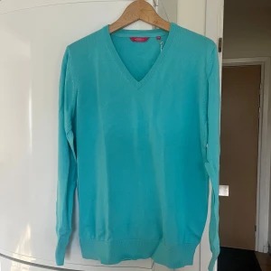 Turkos tröja från Race Marine - Säljer en snygg turkos tröja från Race Marine i ekologisk bomull. Tröjan har en v-ringad hals och långa ärmar, perfekt för en stilren look. Passar bra till både jeans och chinos. Perfekt för vår och sommar!