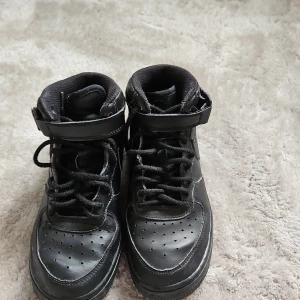 Svarta nike air force ones - Säljer ett par svarta Nike Air force one  sneakers i storlek 36. Skorna har en klassisk design med snörning och kardborreband för extra stöd. Perfekta för vardagsbruk med en stilren look.