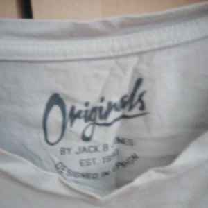 Grå t-shirt från Jack & Jones - Säljer en grå t-shirt från Jack & Jones med tryck på framsidan. T-shirten har en rund hals och korta ärmar. Perfekt för en avslappnad stil.