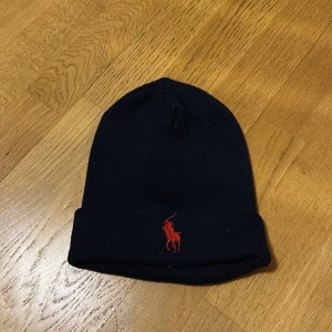 Marinblå Ralph Lauren mössa - Säljer min ralphlauren mössa då den inte längre kommer till användning. Den är i bra skick!