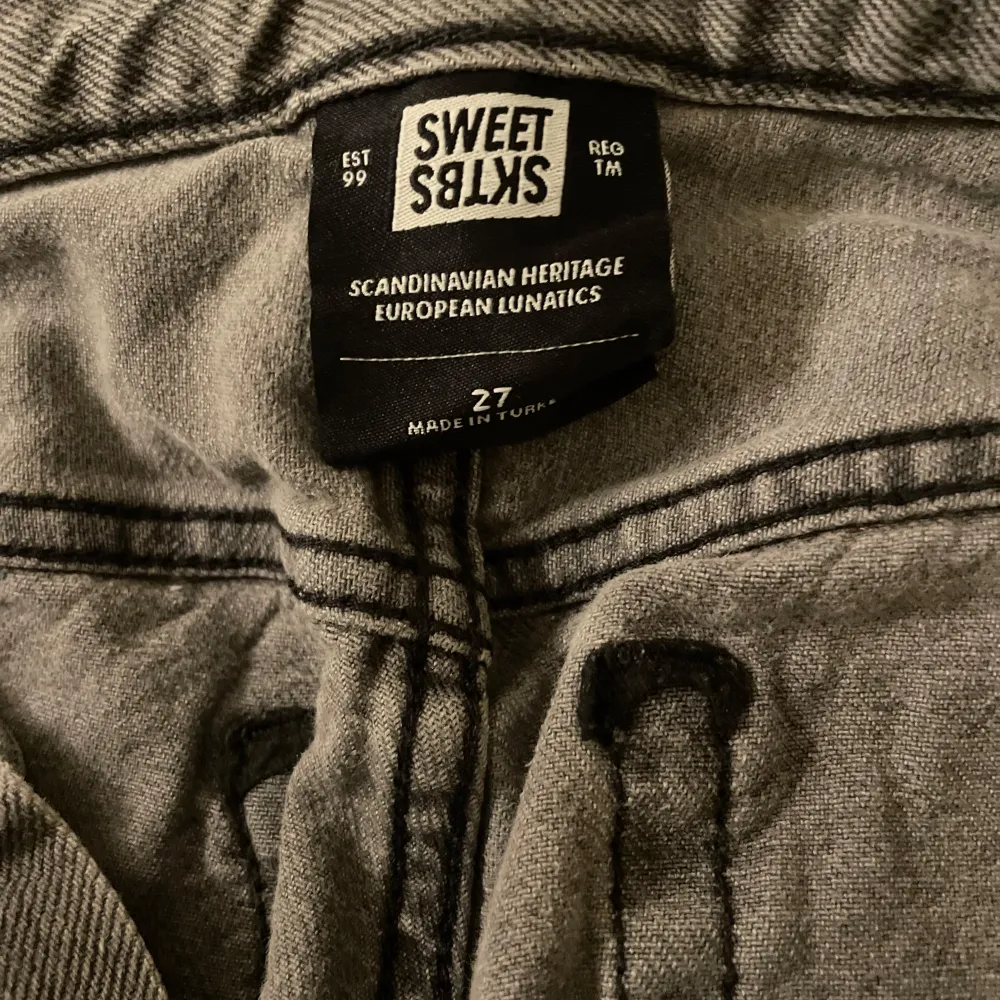 Snygga grå jeans från Sweet Sktbs med en klassisk femficksdesign. De har en knappgylf och en stilren look som passar perfekt till vardags. Tillverkade i ett slitstarkt material som ger en skön passform.. Farkut & Housut.