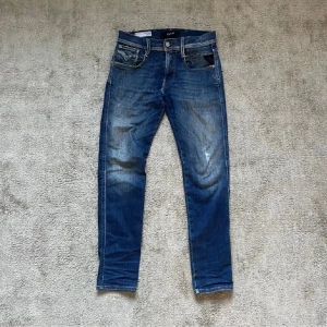 Blå jeansbyxor från Replay - Snygga blå jeansbyxor från Replay, modell Anbass. De har en klassisk femficksdesign med dragkedja och knapp. Perfekt för en avslappnad stil med en modern touch.