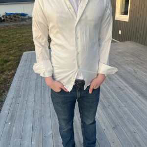 Vit skjorta med knappar från eton  - Säljer en stilren vit skjorta med knappar. Skjortan har långa ärmar och en klassisk design som passar till många tillfällen. Perfekt för en snygg och enkel look. (Vi stryker den innan vi sickar)