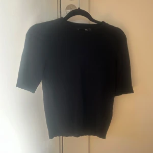 Svart fin stickad  kortärmad topp från Lager 157 storlek XS - Säljer en stilren svart topp med korta ärmar. Perfekt för en minimalistisk look. Passar bra till både jeans och kjol.