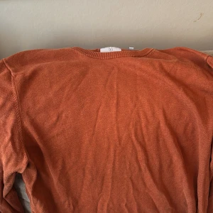 Orange tröja från Bläck - Säljer en snygg orange tröja från Bläck. Tröjan har en enkel design med rund hals och långa ärmar. Perfekt för en avslappnad stil. Tröjan är knappt använd och är i ett mycket bra skick. Tröjan är även i storleken L. Bara att höra av er om ni har några frågor😊