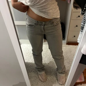 Grå jeans från Gina Tricot - Snygga grå jeans från Gina Tricot med en klassisk femficksdesign. De har en rak passform och är perfekta för en avslappnad stil. Jeansen har en knappgylf och bälteshällor för extra stil och funktionalitet. Se defekt 2 sista bilder