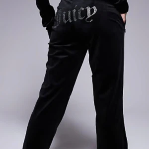 Svart mjukis sett  från Juicy Couture - Snygg svart mjukis sett från Juicy Couture med glittrig text på baksidan. Settet har en bekväm passform och är perfekta för en avslappnad stil. De är tillverkade i ett mjukt material som ger en lyxig känsla.