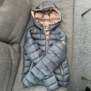 colmar jacka xs  - så fin mörkblå colmar jacka passar mig som har xs. fint skick förutom ett litet hål nere vid ryggen (se bild). hänget på dragkedjan har åkt av men inget som påverkar funktionen, dragkedjan går att dra upp och ner som vanligt 💞 färgen syns bäst på sista bilden!