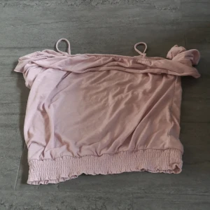Rosa axelbandslös topp från H&M - Säljer en söt rosa axelbandslös topp från H&M. Toppen har smala axelband och en elastisk nederkant som ger en fin passform. Perfekt för varma sommardagar!