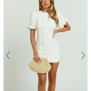 Vit kortklänning med puffärmar från Showpo - Snygg vit kortklänning med puffärmar och dekorativa detaljer. Klänningen har en öppen rygg med knytning och fina spetskanter. Perfekt för studenten. Aldrig använt då den är lite för kort på mig som är 177cm lång, köpte den från showpo för 800kr men med frakt kostade den 1200kr men säljer för 950kr🤗🤗(liten i storleken)