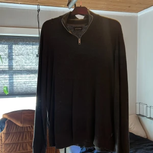 Mörkgrå tröja med dragkedja från Jack & Jones - Säljer en stilren mörkgrå tröja från Jack & Jones med dragkedja vid halsen. Tröjan har långa ärmar och ribbade muddar vid ärmslut och nederkant. Perfekt om du vill ha en stilig outfit. Stl XL, men passar också L. Vid minsta fundering eller fråga så är det bara att höra av sig.