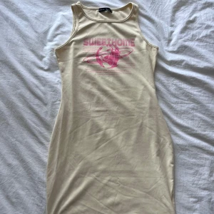Ljusgul kort klänning från SHEIN - Säljer en ljusgul, tight och ärmlös klänning från SHEIN med coolt rosa tryck och texten 'SWEETHOME' framtill. Klänningen har en rund halsringning och är gjord i mjuk bomull, perfekt för dig som gillar en enkel men trendig look.