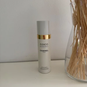 Chanel Coco Mademoiselle Deodorant - Lyxig deodorantspray från Chanel Coco Mademoiselle, 100 ml. Flaskan är elegant och cylinderformad i vit plast med en stilren guldaccent vid korken. Doften är fräsch och feminin, perfekt för dig som gillar exklusiva märken och vill ha en sofistikerad touch i din vardag. Förutom att den höjer din personliga doft/ säkerställer den också en långvarig och effektiv skydd mot oönskad lukt. ☀️Den är aldrig använd utan har använts som prydnad. 