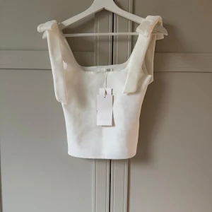 Vit linnetopp med rosett från Zara - Supersöt vit linnetopp från Zara med rosetter på banden🥰🙌Passa till allt😍aldrig använt med prislapp❤️