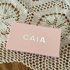CAIA Prisma Palette Flirty - Säljer CAIA Prisma Palette Flirty med två pressade puder – en skimrande ljusrosa highlighter och en varm persikotonad rouge. Paletten har en snygg rosa förpackning med spegel och vågigt mönster i pudret. Perfekt för att ge glow och färg till kinderna. Swatchade en gång pyttelite men syns knappt ☺️ Superfin palett!!