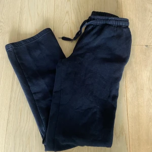 Mörkblå mjukisbyxor Gina Tricot XS - Snygga mörkblå mjukisbyxor från Gina Tricot, basically basics-kollektionen. De har rak passform, resår och snörning i midjan för extra komfort. Perfekta för chill dagar eller när du vill vara extra bekväm. Materialet är mjukt och skönt.