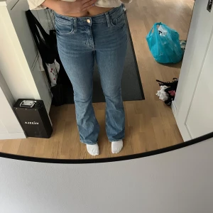 Blå flare jeans - Säljer ett par snygga blå flare jeans från HM storlek 38. Modellen har hög midja och klassisk femficksdesign. Jeansen är tillverkade i mjukt denimtyg och har en riktigt schysst passform med utsvängda ben. 