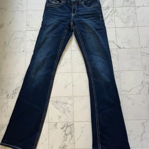 Blå bootcut jeans från Gina Tricot - Säljer dom här lågmidjade jeansen från Gina Tricot då dom aldrig kommer till användning. Jeansen är inprincip oanvända och har inga skador eller likande.