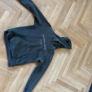 Grön hoodie från Björn Borg - Säljer en svart hoodie från Björn Borg med tryckt logga på bröstet. Tröjan har huva med snörning, en stor magficka och långa ärmar. Perfekt för chill eller träning, riktigt skön och stilren design. STORLEK 170