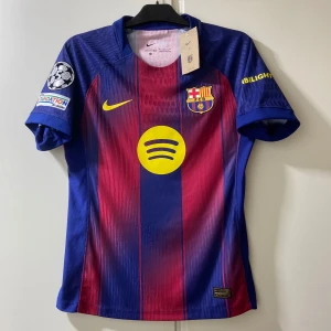 FC Barcelona Lamine Yamal matchtröja - Säljer en FC Barcelona matchtröja med Lamine Yamal och nummer 10 på ryggen. Tröjan är kortärmad, har klassiska blå och röda ränder, gula detaljer och klubbmärke på bröstet. Materialet är lätt och andas, perfekt för fotboll. UEFA Foundation och Spotify-logga finns på ärm och bröst.