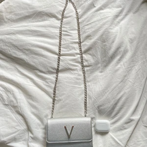 Mario Valentino DIVINA crossbody bag - Snygg liten axelväska från Mario Valentino i silver med en kedja som axelrem och en stor V-detalj på framsidan. V:et är lite slitet💕