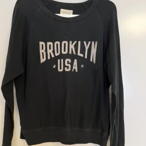 Svart sweatshirt Brooklyn USA Ralph Lauren - Svart sweatshirt från Denim & Supply Ralph Lauren i storlek XS. Tryck med texten BROOKLYN USA i vitt framtill. Rund hals och långa ärmar, tillverkad i mjuk bomull. Perfekt för dig som gillar streetstyle och vill ha en chill look.