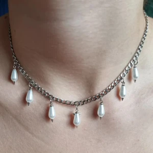 Handgjort halsband  - Kedjehalsband i silverfärg med sju hängande droppformade vita pärlor. Rostfrit stål, glaspärlor. Längd-40cm,kedjetjocklek-4cm 