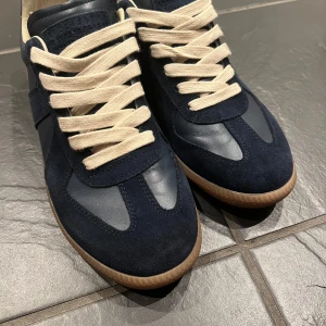 Blå sneaker från Maison Margiela - Blå sneakers från Maison Margiela. Storlek 43, använda i en vecka. Obs ingen låda medföljer. Dustbag fås med! Hör av dig vid intresse! 