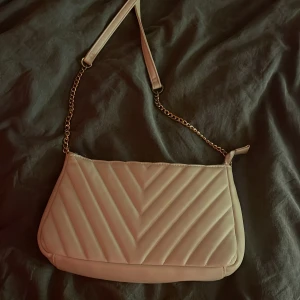 Beige quiltad axelväska med kedja - säljer min väska då jag aldrig använder den och den är använd 1 gång. säljer för 100kr då jag köpte den för 200