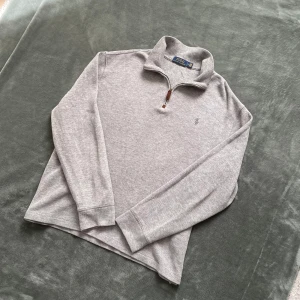 Polo Ralph Lauren Half Zip - Säljer en stilren grå half zip från Polo Ralph Lauren med klassisk krage. Tröjan är i mjuk bomull och har en broderad logga på bröstet. Står L på etikett men skulle säga att den passar bättre på M. Perfekt för lager-på-lager och enkel att matcha.  Nypris 2300kr!💸 Tveka inte på att skriva om du har några funderingar! 🙌Priset är ej hugget i sten! 🪨 