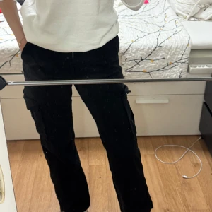 Svarta cargopants med raka ben - Säljer ett par svarta cargopants med raka ben och fickor på sidorna. Aldrig använt och är i väldigt bra kick 