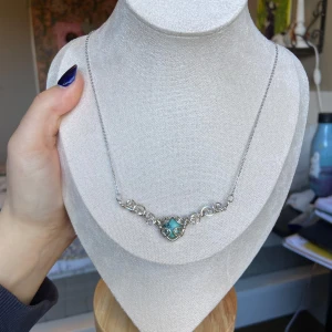 Handgjort silverhalsband - Silverhalsband i elegant design med snirkliga detaljer och en turkos sten formad som ett hjärta. 