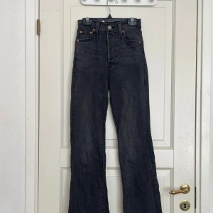 Svarta Levis 501 jeans med hög midja - Säljer ett par svarta Levis 501 jeans med hög midja och raka ben. Klassisk femficksmodell med knappgylf och Levis-logga bak. Perfekta till vardags för en tidlös look.