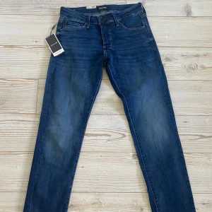 Jack & Jones jeans - Säljer ett par mörkblå jeans från Jack & Jones (modell slim Glenn) med klassisk femficksdesign och raka ben.🔥Jeansen har en snygg tvätt.🙌 Märkeslappar och etiketter sitter kvar.✅ W30 L32💯